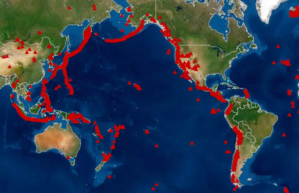 Satellite map displaying the Ring of Fire, a horseshoe-shaped region encircling the Pacific Ocean, with red triangles indicating active volcanoes. The map highlights the concentration of volcanic activity along tectonic plate boundaries.